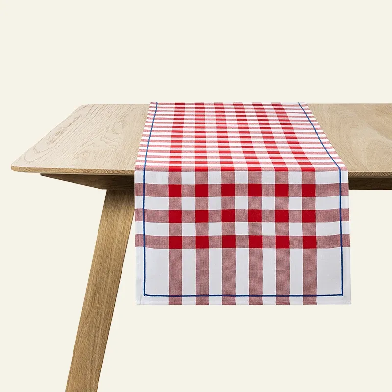 Le Jacquard Français Bistrot Français table runner in red gingham check on a wood table.
