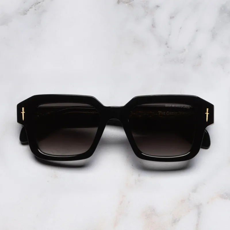 An image of the The Great Frog Bones Link Rectangle Sunglasses in Black frame frontal view with arms closed marble background