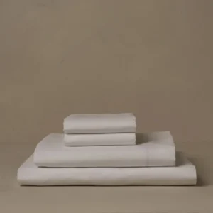 LETTO Giza Reserve Percale sheet set folded in ivory stacked on neutral surface.