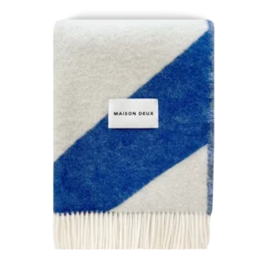 Cobalt blue and white swirl wool blanket folded with fringe detail
